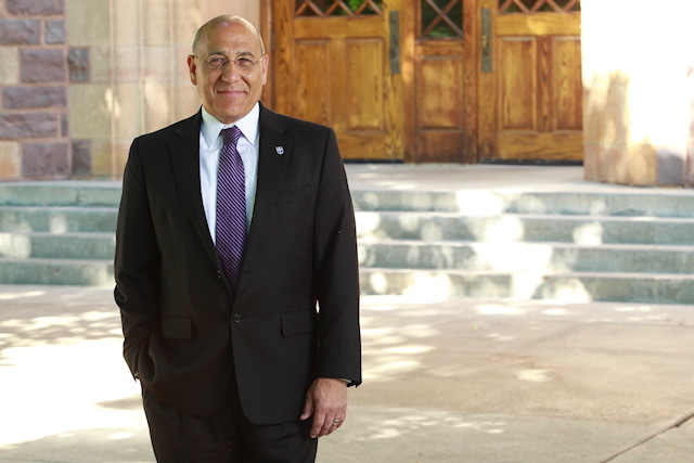 The president of USF - Dr. Brett Bradfield standing in front of a building on campus
